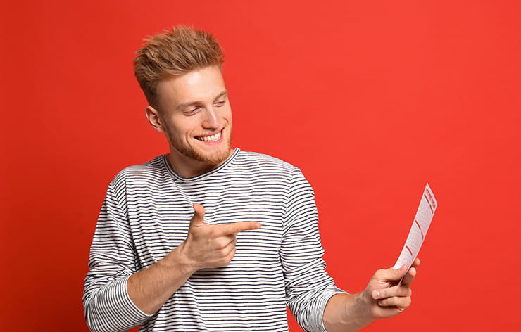 A man pointing at a lottery ticket.